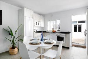 a white kitchen with a white table and chairs at Casa Marion in El Golfo