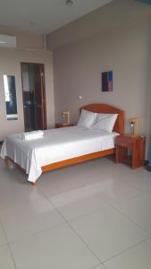 1 dormitorio con 1 cama grande con marco de madera en HOTEL RAYMONDI en Pucallpa