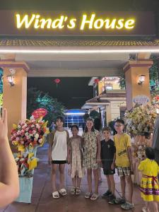 a group of children standing in front of a windmill house at Wind's House Ha Giang in Ha Giang