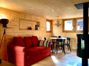 sala de estar con sofá rojo y mesa en LA CÀ NOVA. South Switzerland cozy gate away. en Osco