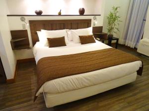 - une chambre dotée d'un grand lit avec des draps et des oreillers blancs dans l'établissement BHB Hotel Boutique, à Santiago