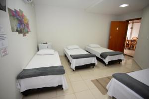 a hospital room with three beds in it at Ribeiro Flat in Araxá