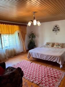 a bedroom with a bed and a rug on the floor at Goni Guest House in Tepelenë