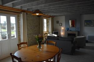 a living room with a table and a couch at Les Chaufourniers/L'Etable in Crouay +5 photos