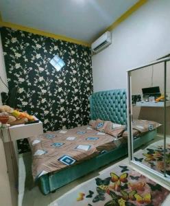 um pequeno quarto com uma cama e um espelho em Felix guest house em Tegal