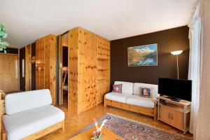 ein Wohnzimmer mit weißen Möbeln und einem TV in der Unterkunft Augusta Praetoria Pila in Gressan