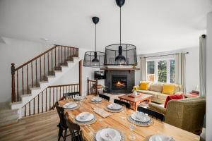a living room with a table and a fireplace at Townhouse On The Golf W Pool Access -aiglon 1666 in Mont-Tremblant