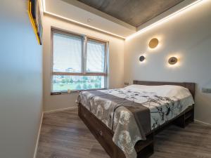 a bedroom with a bed and a large window at Cozy Apartment Vilnius in Vilnius