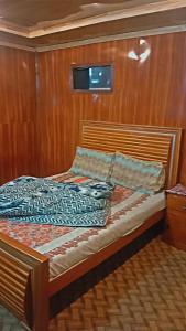 a small bed on a boat in a room at Northern Huts And Riverview Restaurant in Bālākot