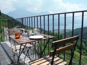 un tavolo e sedie su un balcone con vista di Apartments Gravedona Panoramic a Gravedona