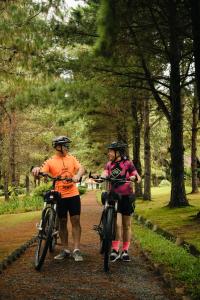 2 Persone con Biciclette su un sentiero in un parco di Pousada O Cantinho da Raposa a Monte Verde