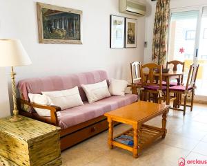 a living room with a couch and a table at Acogedor SierraMar 1era Línea in Oropesa del Mar