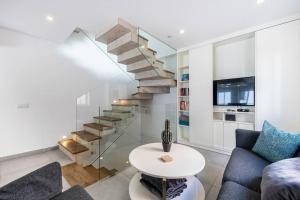 a living room with a staircase and a table at Casa Machado in Lagos