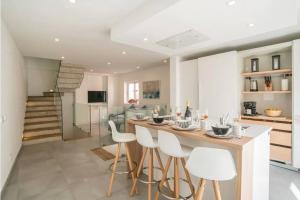 a kitchen with a large island with white stools at Casa Machado in Lagos