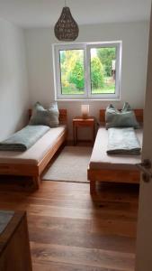 2 Betten in einem Zimmer mit 2 Fenstern in der Unterkunft Kempten mit Bauernhof-Flair in Kempten