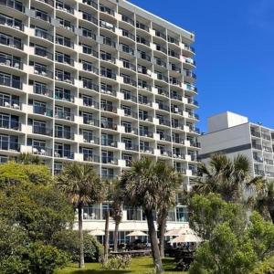 a large building with palm trees in front of it at Boardwalk Beach Resort in Myrtle Beach