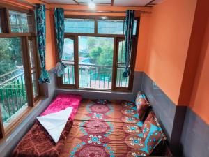 a small bed in a room with two windows at The Kashi Baba Homestay in Dharamshala