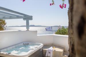 a hot tub on a balcony with a view of the ocean at Saint John Hotel Villas & Spa in Agios Ioannis Mykonos