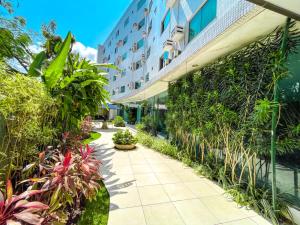 a walkway in front of a building with plants at Hotel Village Confort Campina Grande in Campina Grande