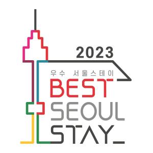 una señal con las palabras mejor estancia lenta y un edificio en Batwo Stay - For foreigners only en Seúl