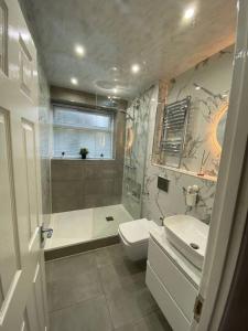 a bathroom with a shower and a toilet and a sink at One Bedroom Flat in Chiswick W4 in London