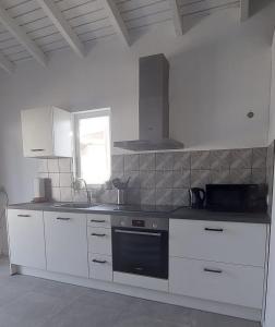 a kitchen with white cabinets and a black oven at Morning Star Aruba in Oranjestad