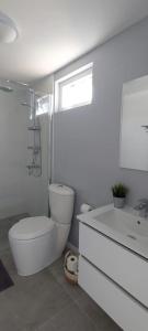 a white bathroom with a toilet and a sink at Morning Star Aruba in Oranjestad