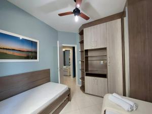 1 dormitorio con 1 cama y ventilador de techo en APÊ BLUE (8min a pé da Praia do Forte), en Cabo Frío
