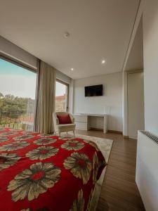 Schlafzimmer mit einem Bett, einem TV und einem Fenster in der Unterkunft Quinta de VillaSete in Alpendurada