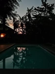 a reflection of a person in a pool at sunset at Aloha Lodge in Cape Town