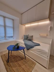 Cette petite chambre comprend un lit et une table bleue. dans l'établissement Les appartements Hyper centre, à Strasbourg