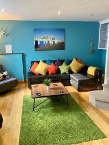 a living room with a couch and a green rug at Pebble Mews House - By My Getaways - parking for one small car in Brighton & Hove