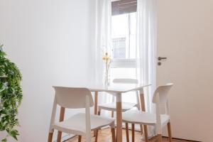 un comedor blanco con mesa y sillas en Fliphaus Borges 2200 - Petit Apt Palermo Soho en Buenos Aires