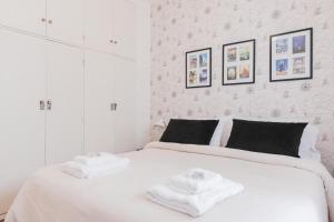 1 dormitorio blanco con 2 toallas en una cama en Fliphaus Borges 2200 - Petit Apt Palermo Soho en Buenos Aires