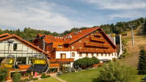 a house with a ski lift in front of it at Hotel Meta Resort & Vine SPA in Szczyrk