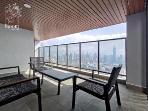 una camera con sedie e tavolo e vista sulla città di Trion KL High floor Corner Unit Free Parking Near TRX KL Centre and MRT a Kuala Lumpur