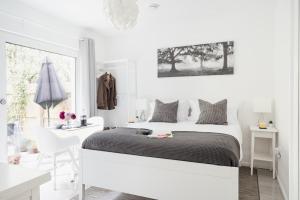 een witte slaapkamer met een groot bed en een bureau bij Siskin Guest Suite in Kinrara