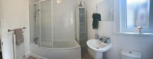 y baño con ducha, aseo y lavamanos. en Spacious 5-Bed Retreat, en Londres