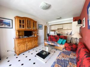 een woonkamer met een rode bank en een keuken bij Apartamento APOLO V 6º Calpe in Calpe