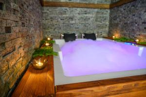 a hot tub in a room with a brick wall at The White Horse Apartmens in Borovets