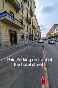 a street with a sign for paid parking on front of the hotel street at Hotel Romano in Turin