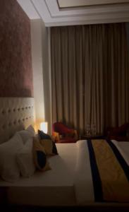 a hotel room with a bed with pillows at Luxury Penthouse with Taj Mahal view in Agra