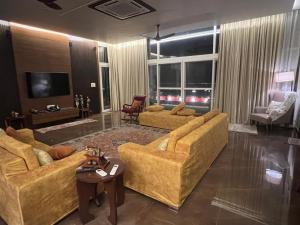een woonkamer met 2 banken en een televisie bij Luxury Penthouse with Taj Mahal view in Agra
