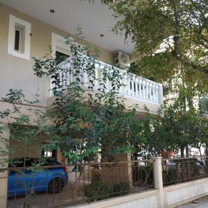 une maison avec un balcon et un arbre en face de celle-ci dans l'établissement Μοντέρνο Studio στο Κέντρο της Λάρισας, à Larissa