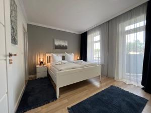 um quarto com uma cama branca e uma grande janela em 130m² Designerwohnung mit 2 Vollbädern em Gera