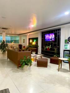 a living room with couches and a flat screen tv at HOTEL MAESJHU in Atacames