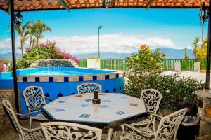 una mesa y sillas en un patio con piscina en Loma Tranquila, en Alajuela