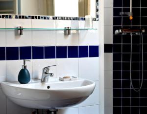 La salle de bains est pourvue d'un lavabo et de carrelage bleu et blanc. dans l'établissement Domus Aurea, à Saluces