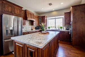 a kitchen with wooden cabinets and a granite counter top at Desert Canyon Retreat W Heated Pool & Desert View in Phoenix