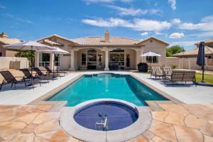 a swimming pool with chairs and a house at Desert Canyon Retreat W Heated Pool & Desert View in Phoenix